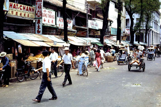 Velosolex Cycle-pousse dans une rue commercante de Saigon