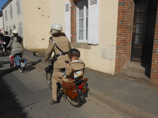 En vélosolex une gendarmette et sa progéniture